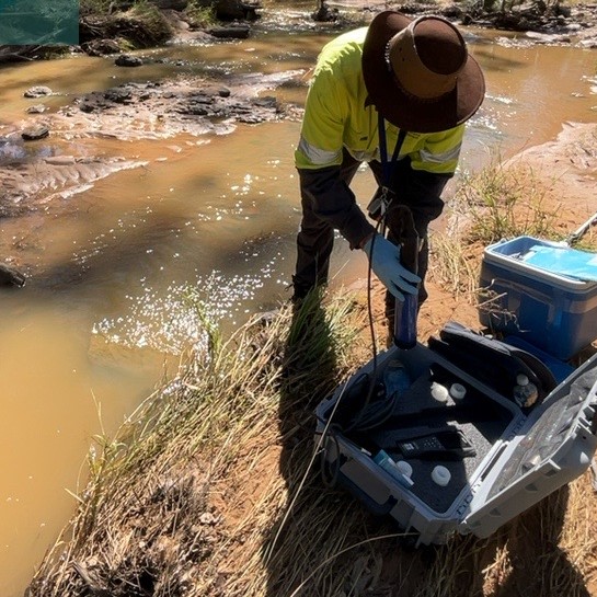 Photo of officer conducting water sampling, which helps us assess environmental impacts.